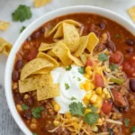 A bowl of taco soup garnished with Fritos