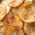 Close-up of crispy homemade potato chips with a sprinkle of salt and pepper.