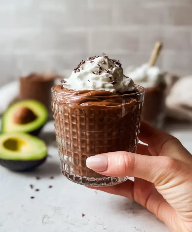 homemade chocolate avocado pudding in cut-glass cup with whipped cream