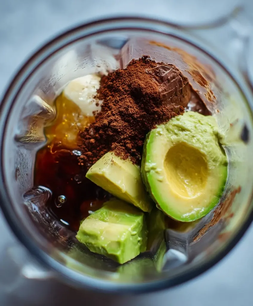 top view of chocolate avocado pudding ingredients inside blender